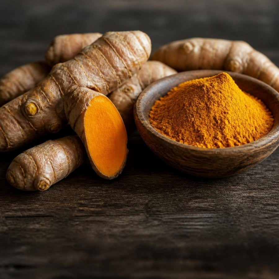 Fresh turmeric roots and a bowl of turmeric powder